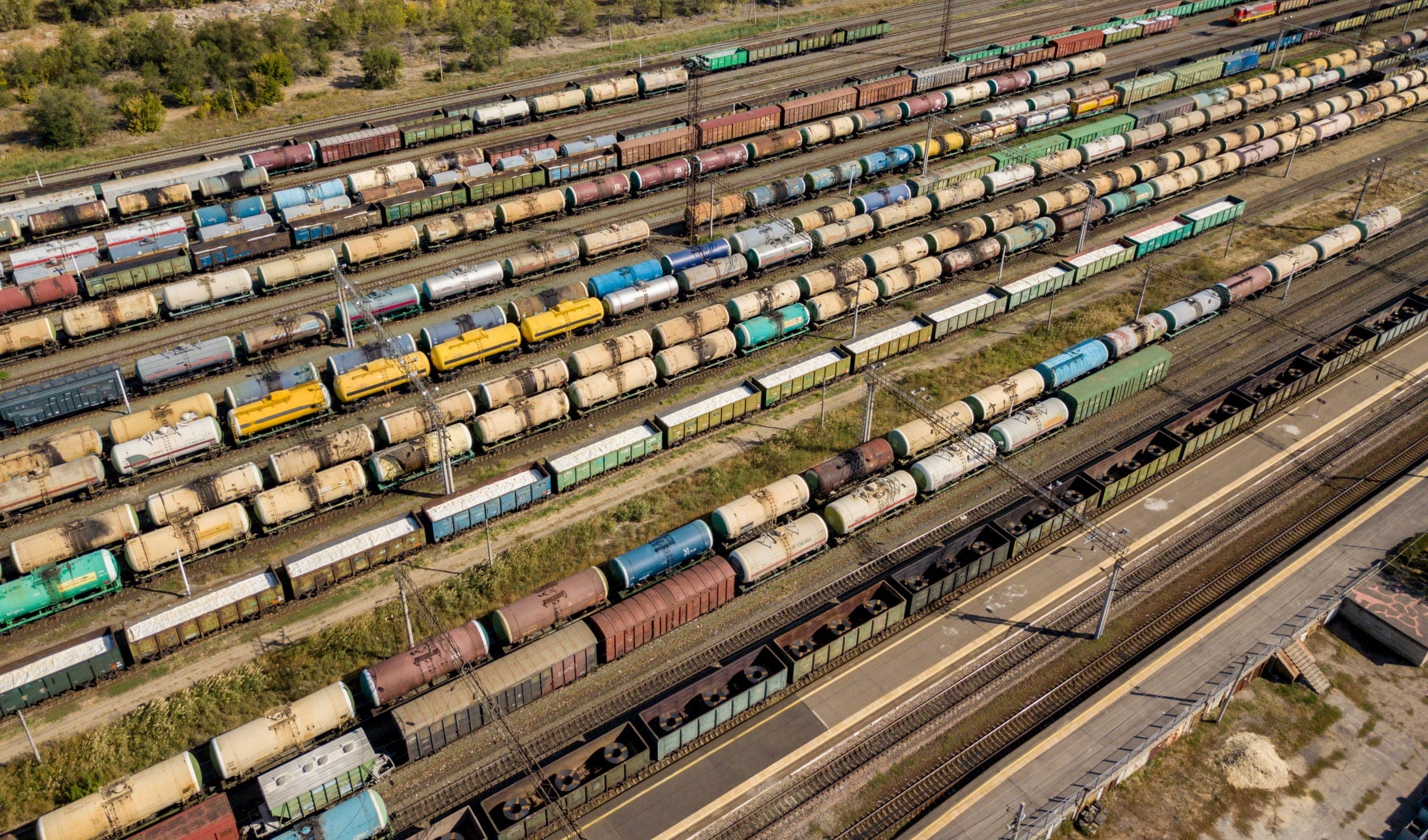 Aerial view of a rail yard filled with tank cars, hoppers, and gondolas standing on parallel tracks