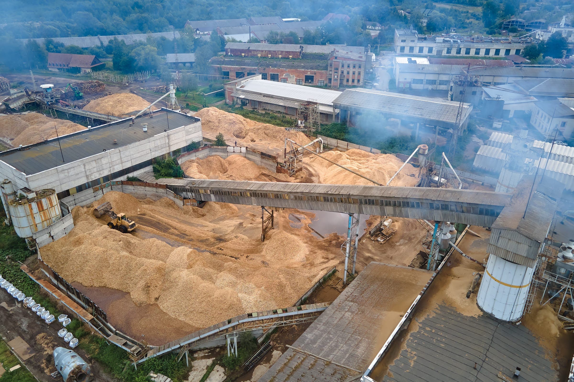 Aerial view of a bulk material yard with large irregular stockpiles
